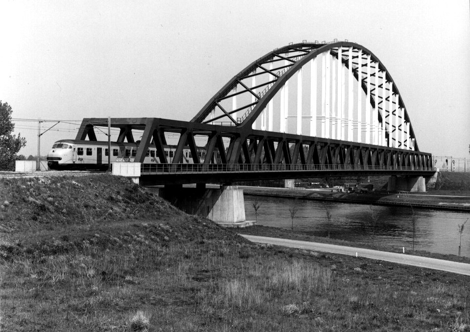 HUA-153579-Gezicht op de nieuwe spoorbrug over het Amsterdam-Rijnkanaal bij Schalkwijk vanuit het zuid-oosten met een electrisch treinstel mat. 1964 (plan V) van de N.S