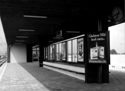 HUA-153233-Gezicht op de perrons van het N.S.-station Rotterdam Lombardijen te Rotterdam, met een wachtbank en een rij reclame-affiches