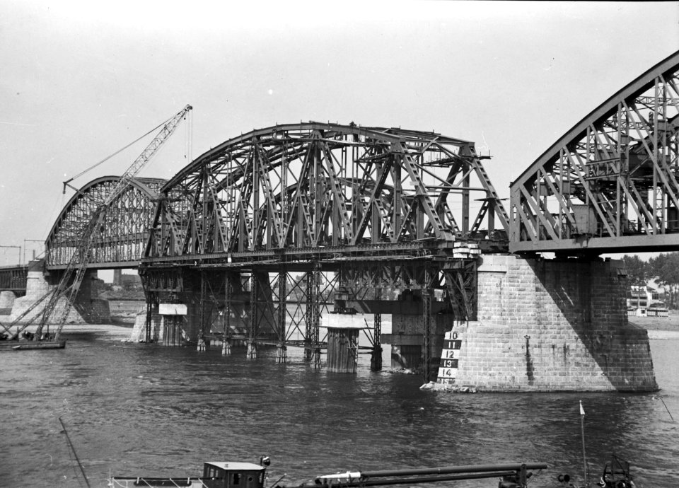 HUA-153547-Afbeelding van de wederopbouw van de spoorbrug over de Waal bij Nijmegen