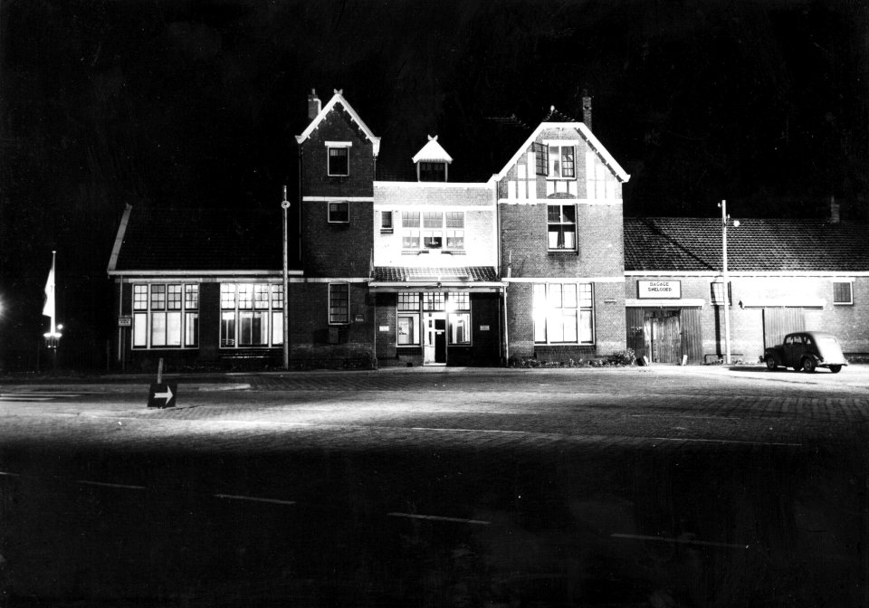 HUA-153821-Gezicht op de voorgevel van het N.S.-station Coevorden te Coevorden, bij avond