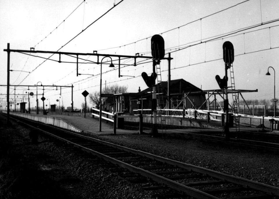 HUA-153112-Gezicht op het perron en het oude N.S.-station Heerhugowaard te Heerhugowaard kort voor de afbraak. Rechts is het nieuwe stationsgebouw in aanbouw