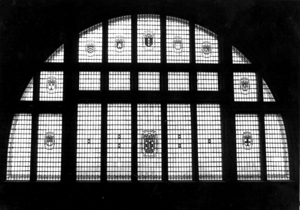 HUA-154001-Detail van de voorgevel van het N.S.-station Haarlem te Haarlem- glas-in-lood venster met diverse gemeentewapens
