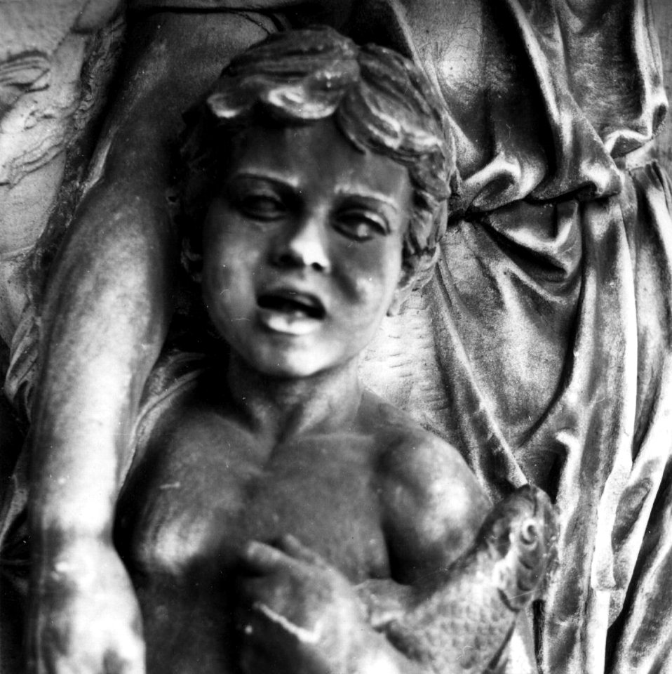 HUA-153748-Detail van het reliëf aan de rechtertoren van het NS station Amsterdam CS te Amsterdam voorstellende een putto met een vis