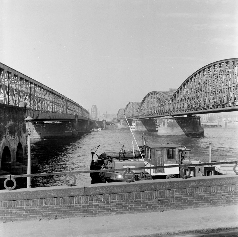 HUA-153573-Gezicht op de bruggen over de Nieuwe Maas te Rotterdam vanuit het zuiden. Links de verkeersbrug en rechts de spoorbrug (Willemsspoorbrug)