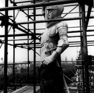 HUA-153776-Gezicht op het koperen beeld "Schilddrager van den Koning" op het dak van het Koninklijk paviljoen van het N.S.-station Amsterdam C.S. te Amsterdam tijdens restauratie