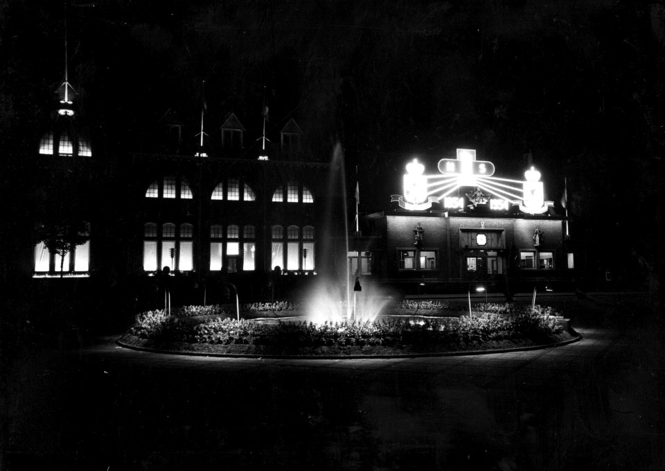 HUA-153823-Afbeelding van de feestverlichting aan de voorgevel van het N.S.-station Roosendaal te Roosendaal, ter gelegenheid van het 100-jarig bestaan van de spoorwegen in Roosendaal