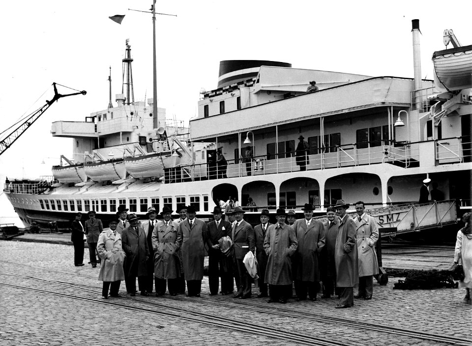 HUA-164066-Afbeelding van een gezelschap op de kade bij het N.S.-station Hoek van Holland Haven te Hoek van Holland, ter gelegeheid van de eerste rit van de Nord-West Express. Op de achtergrond een schip van de 