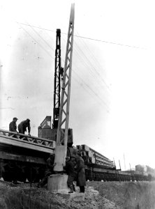 HUA-163985-Afbeelding van het plaatsen van een betonnen bovenleidingsmast ten behoeve van de electrificatie van de spoorlijn Arnhem Zwolle ter hoogte van Gorssel