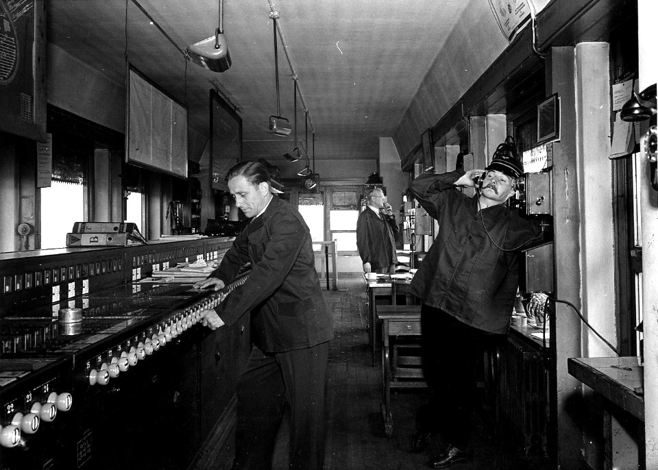 HUA-163917-Afbeelding van leden van het ABC-Cabaret in het seinhuis Post I aan de oostzijde van het N.S.-station Amsterdam C.S. te Amsterdam. N.B. De foto is gemaakt in het kader van de promotie van het programm
