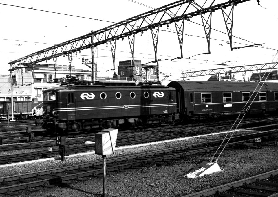 HUA-159546-Afbeelding van een electrische locomotief uit de serie 1100 van de NS met een internationale trein D trein bij het NS station Amsterdam CS te Amsterda