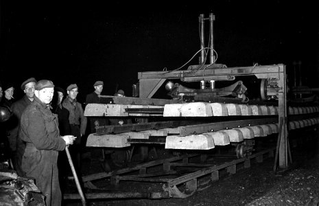 HUA-164102-Afbeelding van het leggen van spoor met betonnen dwarsliggers te Klarenbeek, bij nacht