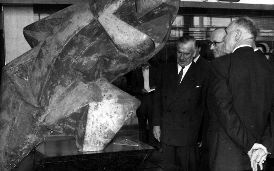 HUA-157710-Afbeelding van dr. ir. F. Q. den Hollander (rechts van het midden, president-directeur van de N.S. van 1947 tot 1958) bij het kunstwerk "Het Afscheid"in de hal van het N.S.-station Rotterdam C.S. te Rotterdam
