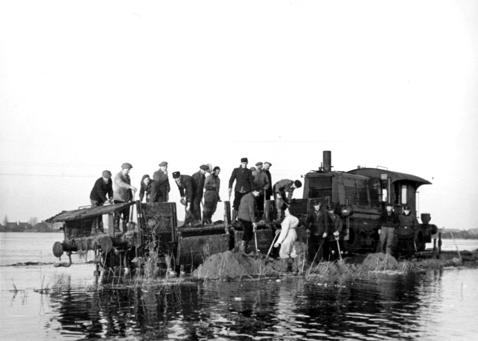 HUA-157034-Afbeelding van herstelwerkzaamheden aan de spoorlijn Lage Zwaluwe - 's Hertogenbosch, nabij Hooge Zwaluwe, met behulp van een locomotor (serie 200-300) van de N.S. en een platte wagen met zand, na de 