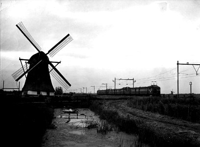 HUA-164065-Afbeelding van twee gekoppelde electrische treinstellen mat. 1946 van de N.S. in een landschap met molen ter hoogte van Hazerswoude