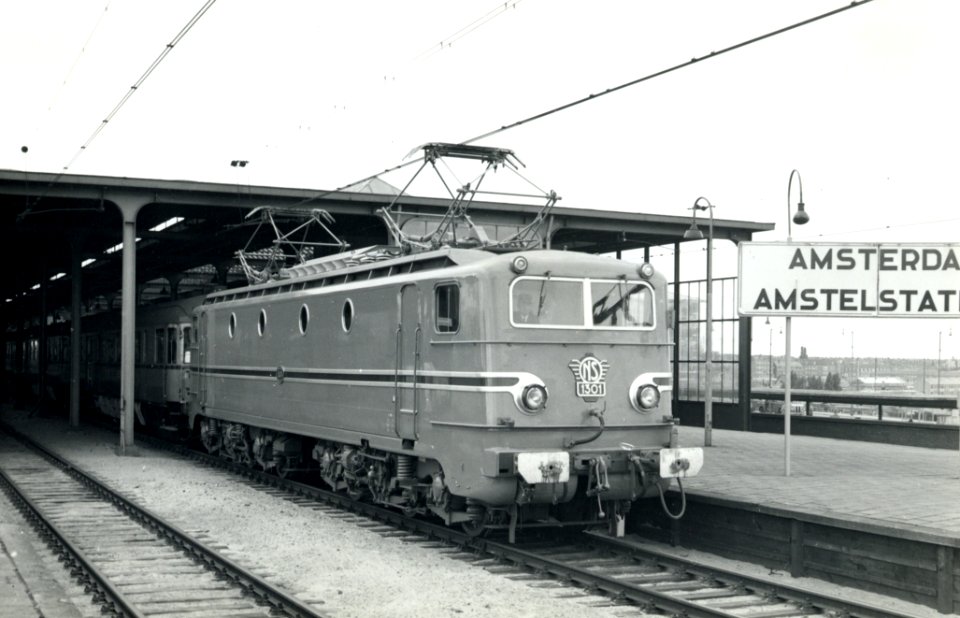 HUA-164063-Afbeelding van de electrische locomotief nr. 1301 (serie 1300) van de N.S. met rijtuigen plan D langs het perron van het N.S.-station Amsterdam Amstel te Amsterdam
