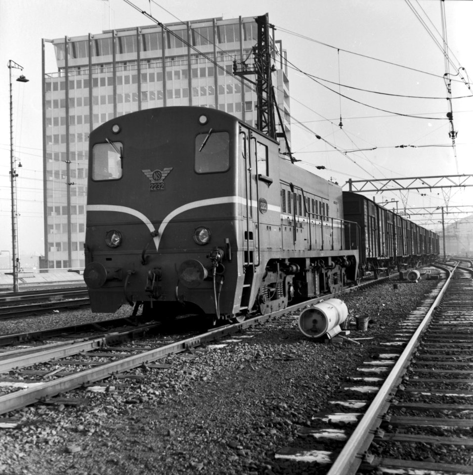 HUA-166586-Afbeelding van de diesel-electrische locomotief nr. 2232 (serie 2200-2300) van de N.S. met een goederentrein te Amsterdam C.S
