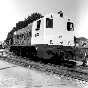 HUA-166581-Afbeelding van de diesel-electrische locomotief nr. 2279 (serie 2200-2300) van de N.S. in de nieuwe geel-grijze huisstijl op het terrein van de Hoofdwerkplaats van de N.S. te Tilburg
