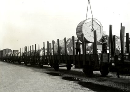 HUA-167307-Afbeelding van het beladen van rongenwagens met haspels met kabels van de N.K.F. (Nederlandse Kabelfabriek) op de laad- en losplaats van het N.S.-station Delft te Delft