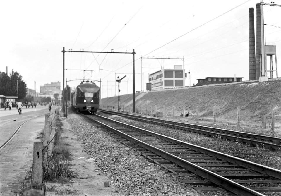 HUA-167197-Gezicht op de hulpspoorbaan te Eindhoven, met een electrisch treinstel mat. 1936 van de N.S., met rechts de spoordijk van het nog niet in dienst gestelde hoogspoor door Eindhoven