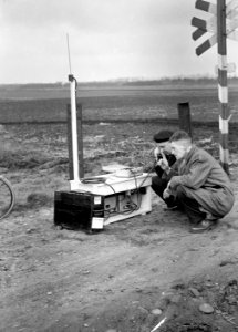 HUA-167440-Afbeelding van twee N.S.-ers met een veldtelefoon langs de spoorlijn nabij Heeze, tijdens onderhoudswerkzaamheden aan de lijn