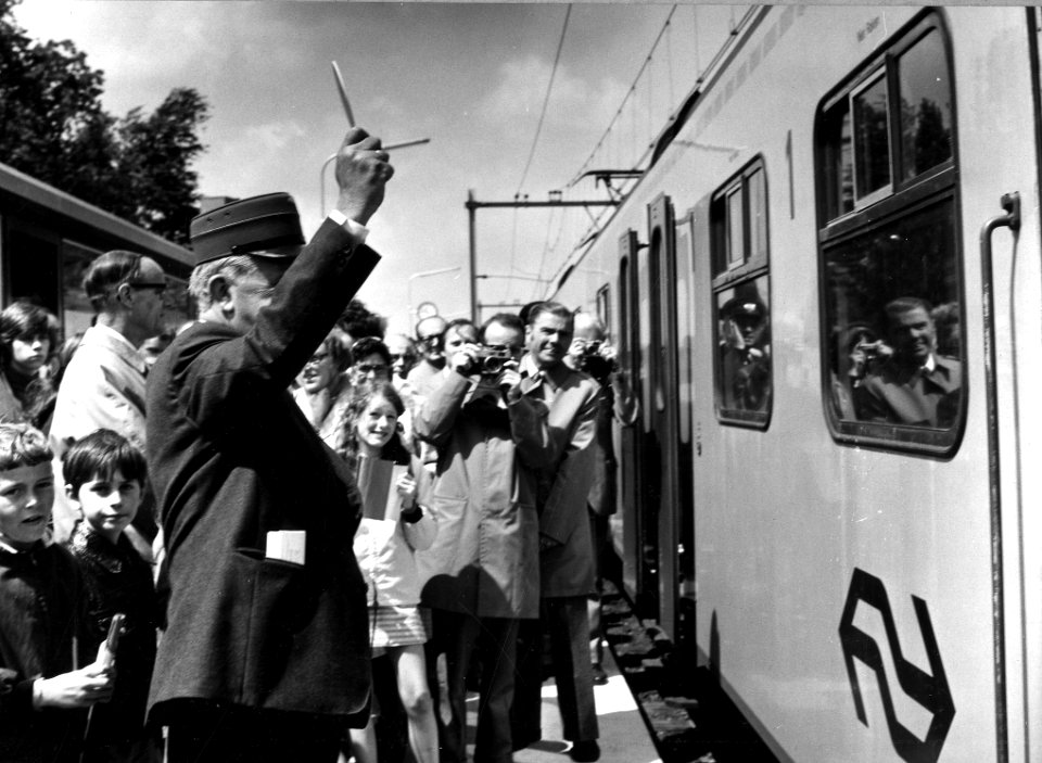 HUA-165568-Afbeelding van de officiële opening van het nieuwe N.S.-station Maarn te Maarn, met links burgemeester mr. G.A.W.C. baron van Hemert tot Dingshof (met stationschefspet) die de openingstrein het vertre
