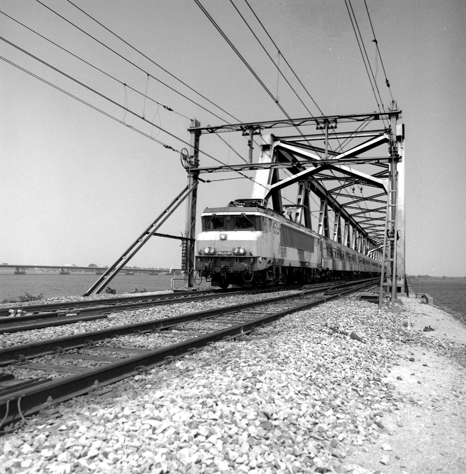 HUA-166603-Afbeelding van de electrische locomotief nr. 1616 (serie 1600) van de N.S. met een trein bestaande uit ICR-rijtuigen op de spoorbrug over het Hollands Diep (Moerdijkbrug) bij Moerdijk