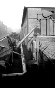 HUA-163953-Afbeelding van het storten van graan in een dekzeilwagen van de N.S. te Rotterdam