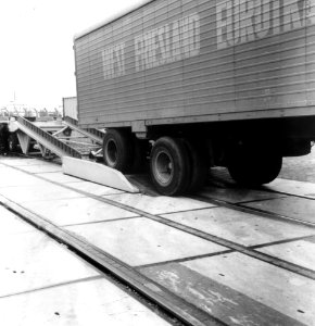 HUA-167027-Afbeelding van het beladen van een platte goederenwagen met een oplegger van een vrachtauto zg Kangourou of Huckepack vervoer 