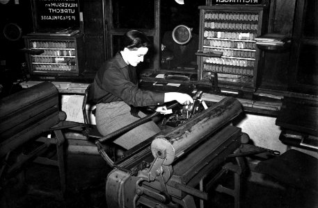 HUA-164127-Afbeelding van een lokettiste in opleiding achter de plaatskaartendrukmachine (type Regina) in het plaatskaartenkantoor van het N.S.-station Amsterdam C.S. te Amsterdam
