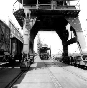 HUA-167039-Gezicht op het kadespoor over de Oostelijke Handelskade te Amsterdam, met dubbeldeks autotrailers beladen met Ford Anglia's
