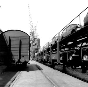 HUA-167041-Afbeelding van dubbeldeks autotrailers van de NS beladen met Ford Anglia s op de Oostelijke Handelskade te Amsterdam