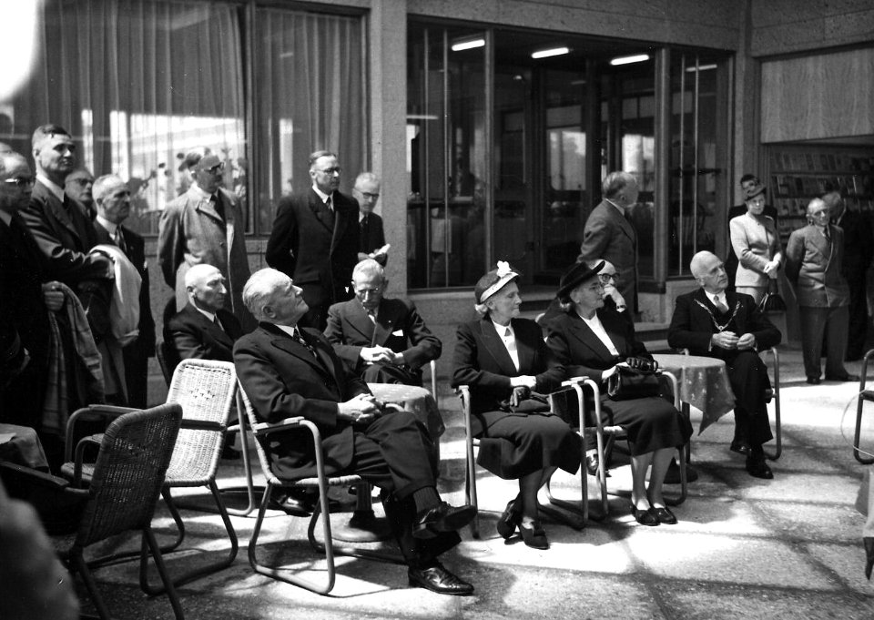 HUA-164059-Afbeelding van de genodigden in de hal van het N.S.-station Zutphen te Zutphen, tijdens de officiële opening van het nieuwe stationsgebouw, met zittend links op de voorgrond de architect van het gebou