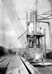 HUA-167004-Afbeelding van het overladen graan van schip naar trein via een elevator in de haven van Rotterdam