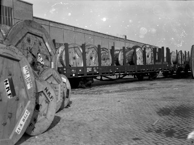 HUA-167308-Afbeelding van een rongenwagen met haspels met kabels van de NKF Nederlandse Kabelfabriek op de laad en losplaats van het NS station Delft te Delft