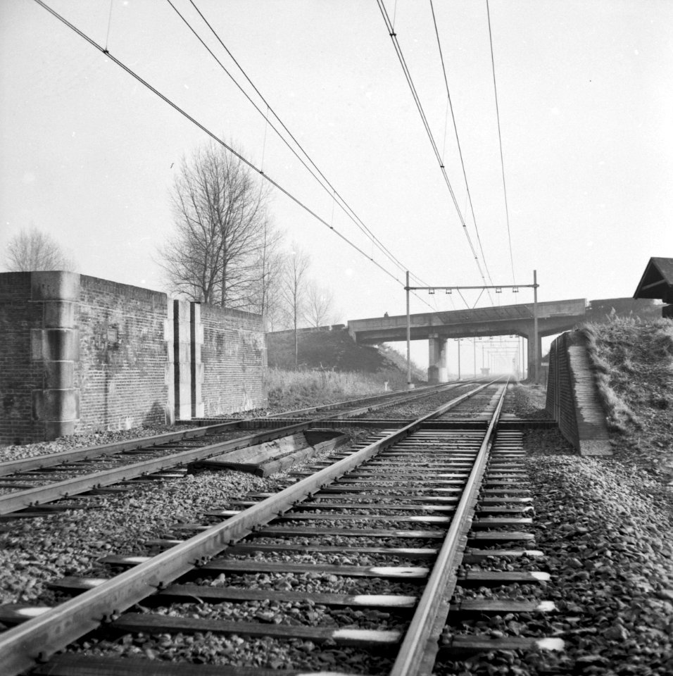HUA-167157-Gezicht op de spoorlijn bij 's-Heer Arendskerke, met op de voorgrond de dijkcoupure en op de achtergrond het viaduct van de Sloeweg