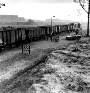 HUA-167177-Afbeelding van het rangeren met een bietentrein te Roosendaal op de spoorwegovergang in de Borchwerf met rechts de diesel electrische locomotief nr 24