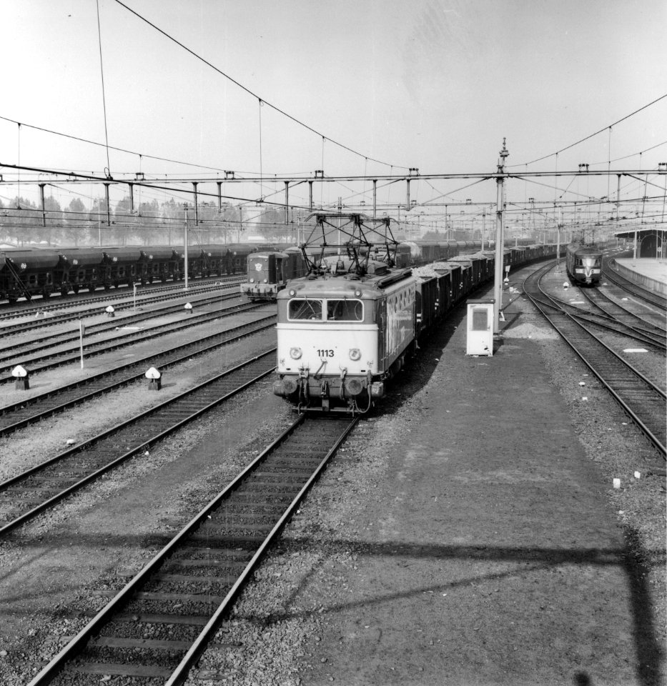 HUA-167020-Afbeelding van de electrische locomotief nr. 1113 (serie 1100) van de N.S. met een bietentrein op het emplacement te Roosendaal