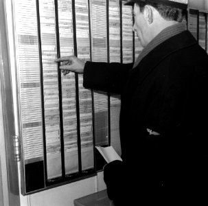 HUA-166742-Afbeelding van een machinist van de N.S. bij het dienstrooster in het Bureau Dagorder in het N.S.-station Utrecht C.S. te Utrecht