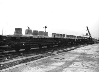 HUA-163804-Afbeelding van het beladen van goederenwagens met betonnen funderingsblokken ("puddingen") voor bovenleidingsmasten op het emplacement van het N.S.-station Lage Zwaluwe