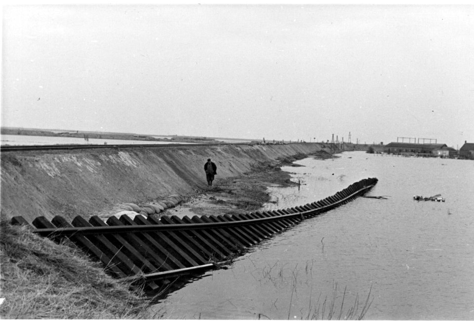 HUA-157010-Gezicht op de herstelde spoordijk (Sloedam) ten oosten van Arnemuiden, na de watersnoodramp, met op de voorgrond een restant van de oude, weggespoelde spoorlijn