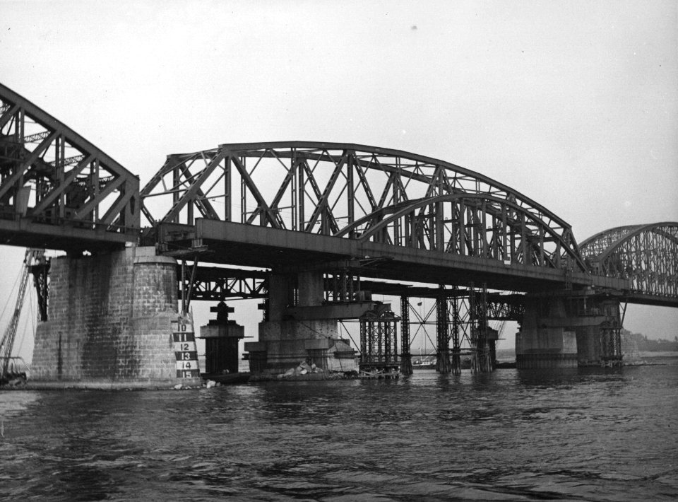 HUA-157319-Afbeelding van de herstellingswerkzaamheden aan de spoorbrug over de Waal te Nijmegen Het laatste nood brugdeel is vervangen door een definitief brugd