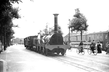 HUA-160419-Afbeelding van de replica van de stoomlocomotief De Arend van de N.S. met rijtuigen op de Westvest te Delft tijdens het 100-jarig jubileumsfeest van de T.H