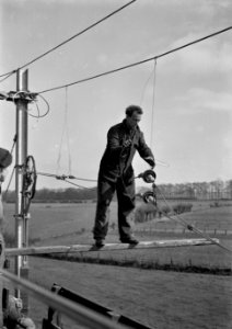 HUA-166467-Afbeelding van een electricien tijdens de montage van de bovenleiding van de spoorlijn tussen Dieren en Brummen, in verband met de electrificatie van het baanvak