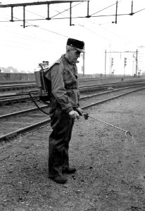 HUA-167406-Afbeelding van een wegwerker van de N.S. tijdens het spuiten van bestrijdingsmiddelen tegen onkruid op het emplacement van het N.S.-station 's-Hertogenbosch te 's-Hertogenbosch