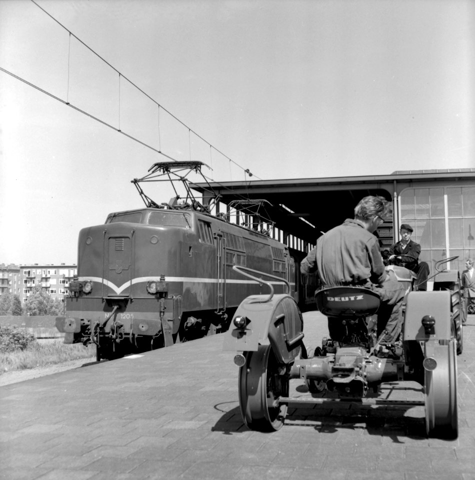 HUA-167045-Afbeelding van het vervoer van landbouwtractoren per trein voor de firma Deutz op het N.S.-station Amsterdam Amstel te Amsterdam, met links de electrische locomotief nr. 1205 (serie 1200) van de N.S