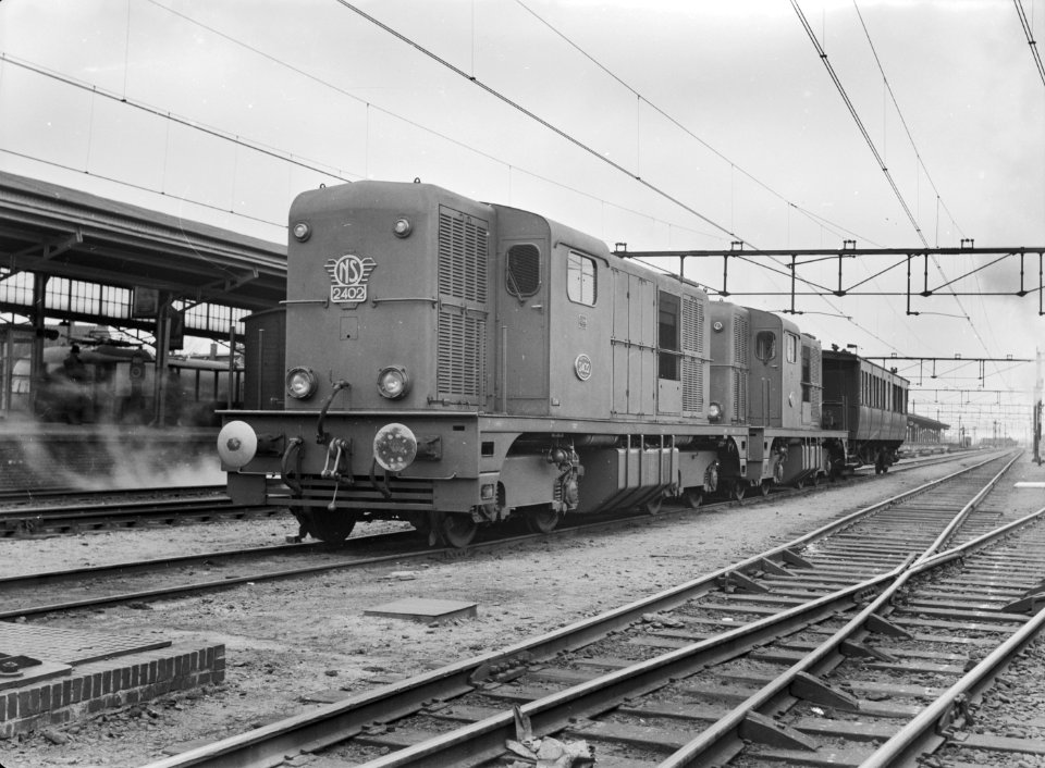HUA-167369-Afbeelding van de diesel electrische locomotieven nrs 2402 en 2401 serie 2400 2500 van de NS met een rijtuig tijdens een proefrit te Almelo