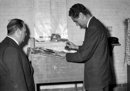 HUA-167002-Afbeelding van het afstempelen van de vrachtbrieven voor het vervoer per trein van de eerste in Nederland geassembleerde Austin A 40 personenauto's bij Molenaars Automobielfabrieken (Nijverheidsweg 61