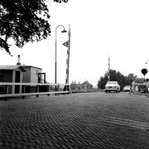 HUA-166537-Gezicht op de spoorwegovergang in de Schaikseweg Spoorstraat te Leerdam met links overwegpost Post I