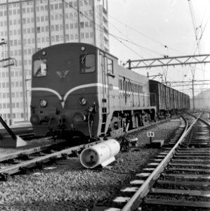 HUA-166584-Afbeelding van de diesel electrische locomotief nr 2232 serie 2200 2300 van de NS met een goederentrein te Amsterdam CS