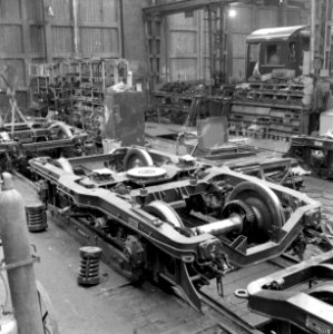 HUA-159420-Afbeelding van in aanbouw zijnde draaistellen voor electrische treinstellen plan F (mat. 1954) voor de N.S. bij de Wagon- en Bruggenfabriek Werkspoor N.V. te Utrecht. Rechts op de achtergrond een in a